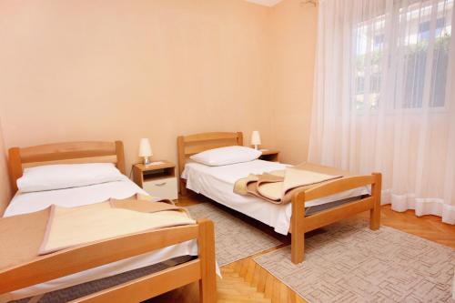 Duas camas num quarto com uma janela em Apartments with a parking space Stari Grad, Hvar - 5730 em Stari Grad