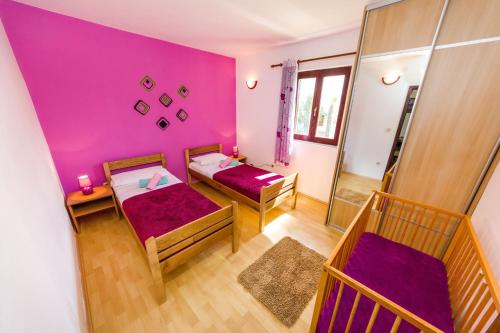 a purple room with two beds and a table at Apartments with a parking space Nin, Zadar - 5857 in Nin