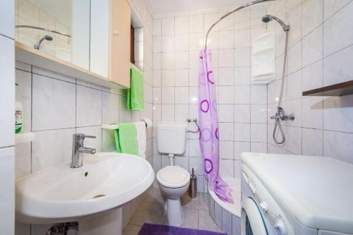 Baño blanco con lavabo y aseo en Apartments with a parking space Nin, Zadar - 5857, en Nin
