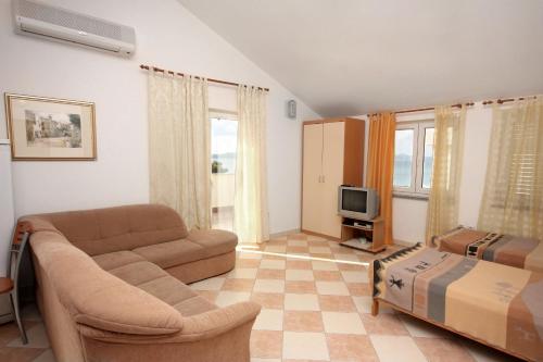- un salon avec un canapé et une télévision dans l'établissement Apartments by the sea Sukosan, Zadar - 5864, à Sukošan