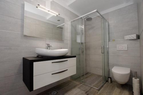 een badkamer met een wastafel en een glazen douche bij Apartments by the sea Kozino, Zadar - 5803 in Kožino