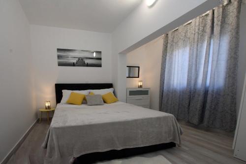 een slaapkamer met een groot bed met gele kussens bij Apartments by the sea Kozino, Zadar - 5803 in Kožino
