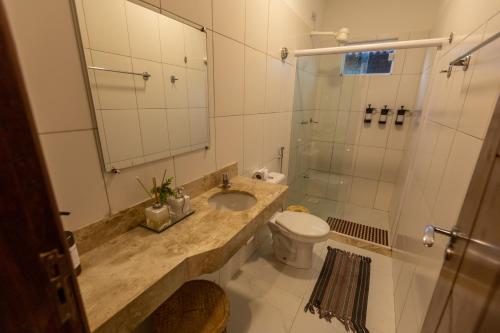 a bathroom with a sink and a toilet and a shower at Pousada Rancho das Dunas in Santo Amaro
