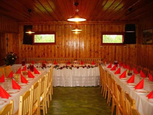 a banquet hall with white tables and red chairs at Kivi Turismitalu in Vardi