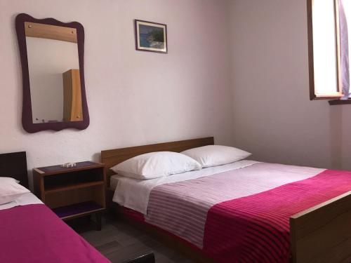 sypialnia z 2 łóżkami i lustrem na ścianie w obiekcie Seaside secluded apartments Cove Pobij, Hvar - 5712 w mieście Gdinj