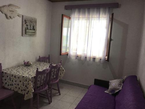 jadalnia ze stołem i fioletową kanapą w obiekcie Seaside secluded apartments Cove Pobij, Hvar - 5712 w mieście Gdinj