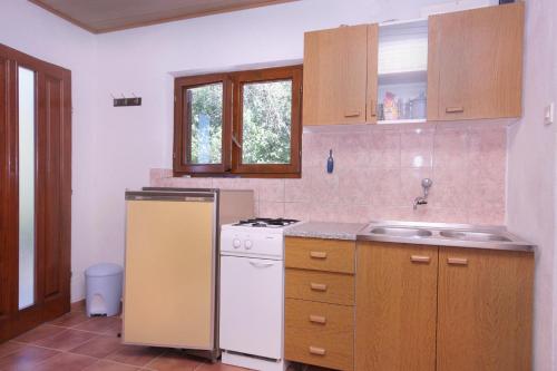 a kitchen with a refrigerator and a stove top oven at Seaside secluded apartments Cove Tatinja, Hvar - 5729 in Vrbanj