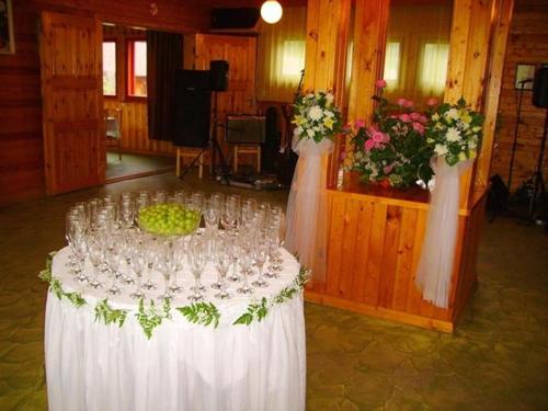 a table with wine glasses and flowers in a room at Kivi Turismitalu in Vardi