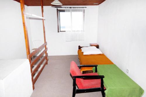 ein Zimmer mit einem Bett und einem Stuhl darin in der Unterkunft Holiday house with a parking space Zavala, Hvar - 5702 in Zavala