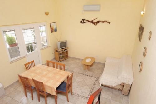 a dining room with a table and chairs and a tv at Apartments by the sea Postira, Brac - 5672 in Postira