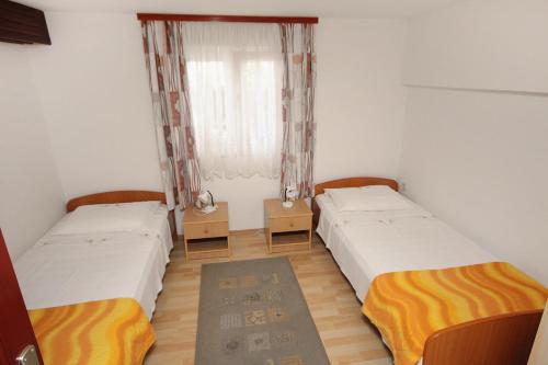 a room with two beds and a window at Apartments by the sea Postira, Brac - 5672 in Postira