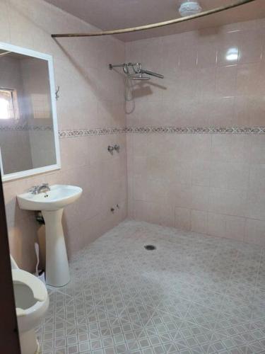 a bathroom with a sink and a toilet and a mirror at Vicalis Hotel, Villas y Glamping in San Sebastian Xolalpa
