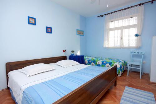 ein blaues Schlafzimmer mit einem Bett und einem Fenster in der Unterkunft Apartments by the sea Ivan Dolac, Hvar - 5709 in Ivan Dolac