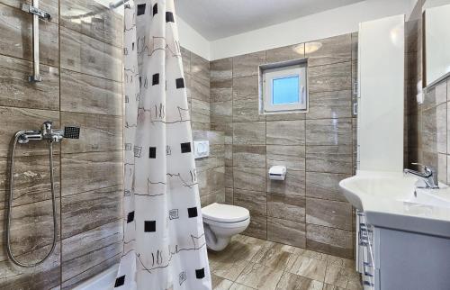 uma casa de banho com um WC, um chuveiro e um lavatório. em Apartments by the sea Basina, Hvar - 5699 em Vrbanj