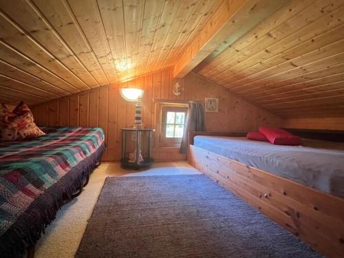 a room with two beds in a wooden cabin at Serene Holiday Home in K gsdorf with Sea View in Kägsdorf