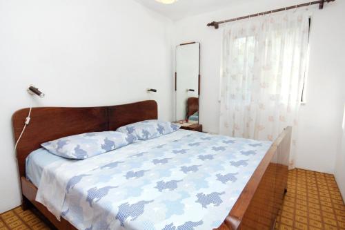 een slaapkamer met een bed met blauwe kussens en een spiegel bij Seaside secluded apartments Cove Zavala - Gdinj, Hvar - 5717 in Bogomolje