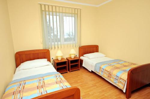 1 dormitorio con 2 camas y ventana en Seaside holiday house Zaton, Zadar - 5910, en Zaton