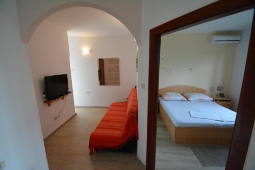 een slaapkamer met een bed en een televisie en een spiegel bij Apartment Kozino 5893a in Kožino