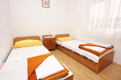 2 camas individuais num quarto com uma janela em Apartments by the sea Rtina - Stosici, Zadar - 5883 em Rtina