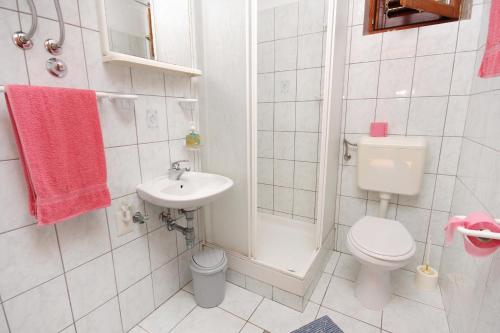 uma casa de banho branca com um WC e um lavatório em Apartments by the sea Rtina - Stosici, Zadar - 5883 em Rtina