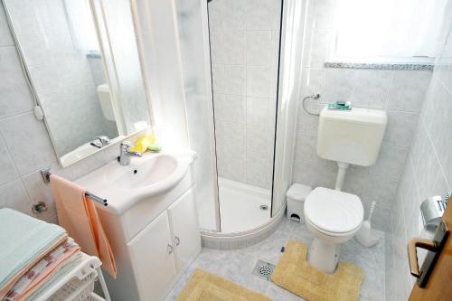 łazienka z prysznicem, toaletą i umywalką w obiekcie Apartments by the sea Kali, Ugljan - 5828 w mieście Kali