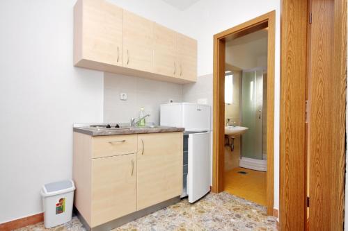 eine Küche mit einer Spüle und einem weißen Kühlschrank in der Unterkunft Apartments by the sea Bibinje, Zadar - 5916 in Bibinje