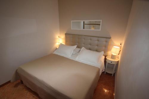 1 dormitorio con 1 cama blanca y 2 lámparas. en Apartments with a parking space Zadar - Diklo, Zadar - 5875 en Zadar