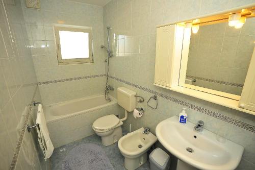 a white bathroom with a sink and a toilet at Apartments by the sea Sukosan, Zadar - 5802 in Sukošan