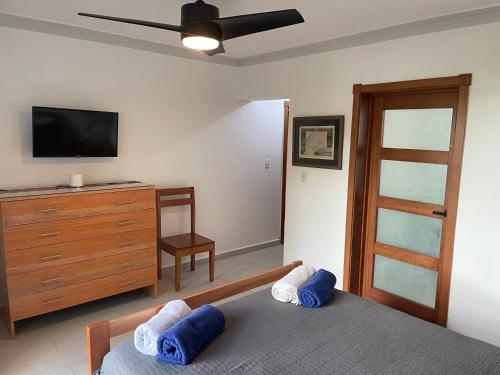 a bedroom with two beds and a tv and a dresser at KITE BEACH Oceanfront LUXURY 1 BEDROOM - All new in 2022 in Cabarete