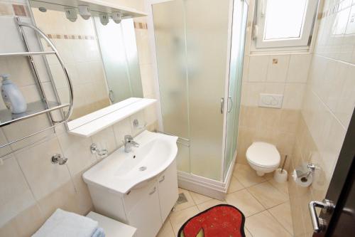 een badkamer met een toilet, een wastafel en een douche bij Apartment Zadar - Diklo 5774d in Zadar