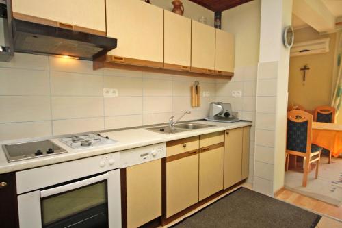 eine Küche mit einer Spüle und einem Herd in der Unterkunft Apartments by the sea Biograd na Moru, Biograd - 5744 in Biograd na Moru