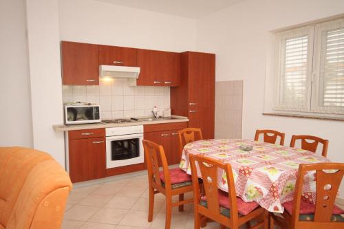 une cuisine avec une table et des chaises ainsi qu'une cuisine avec une cuisinière dans l'établissement Apartments by the sea Vrsi - Mulo, Zadar - 5860, à Nin