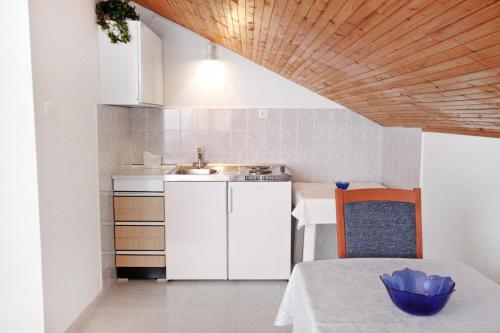 eine kleine Küche mit einem Waschbecken und einem Tisch mit einem Tisch in der Unterkunft Studio Vrsi - Mulo 5796b in Vrsi