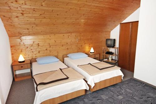 Duas camas num quarto com paredes de madeira em Apartment Vrsi - Mulo 5796a em Vrsi