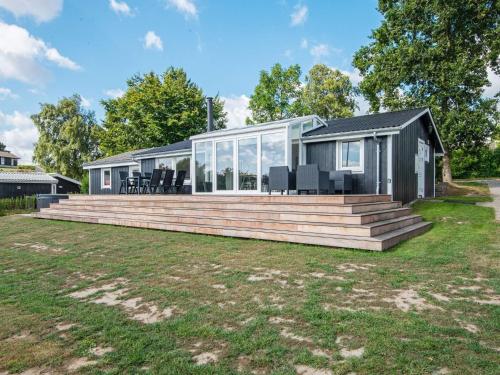 a house with a large wooden deck in the yard at Seaside Serenity in Vemmingbund-By Traum in Broager