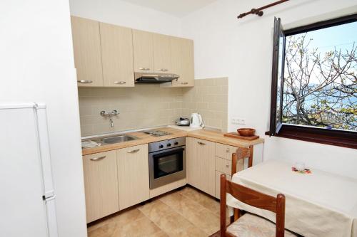 een kleine keuken met een wastafel en een raam bij Apartments by the sea Zadar - Diklo, Zadar - 5911 in Zadar