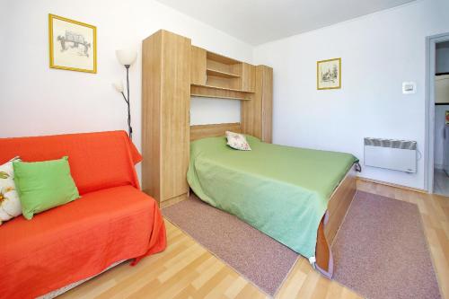 ein Schlafzimmer mit einem Bett und einem Sofa in der Unterkunft Apartments and rooms by the sea Zadar - 5874 in Zadar