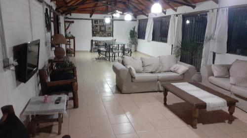 sala de estar con sofás, TV y mesa en Cabañas Lugar Escondido en Mendoza