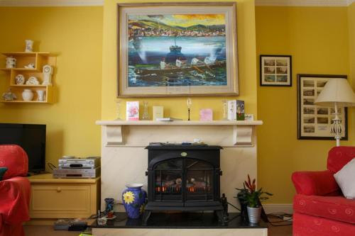 a living room with a fireplace and a painting on the wall at Bambury's Guesthouse in Dingle