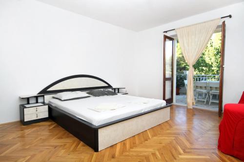 sypialnia z łóżkiem i przesuwnymi szklanymi drzwiami w obiekcie Apartments and rooms with parking space Korcula - 4399 w Korčuli