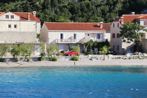 a group of houses on the shore of the water at Apartments by the sea Trstenik, Peljesac - 4570 in Trstenik