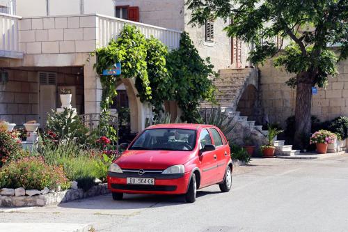 a small red car parked in front of a building at Apartments by the sea Trstenik, Peljesac - 4570 in Trstenik
