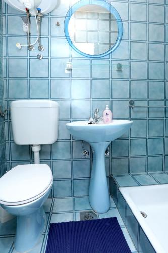 a blue tiled bathroom with a toilet and a sink at Apartments by the sea Trstenik, Peljesac - 4570 in Trstenik