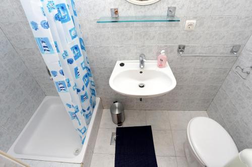 a white bathroom with a sink and a toilet at Apartments by the sea Trstenik, Peljesac - 4570 in Trstenik