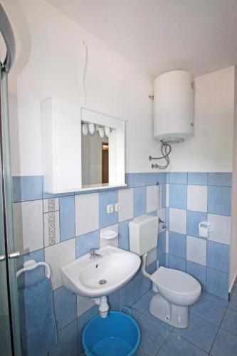 a bathroom with a sink and a toilet and a mirror at Apartment Vinjerac 5824c in Vinjerac