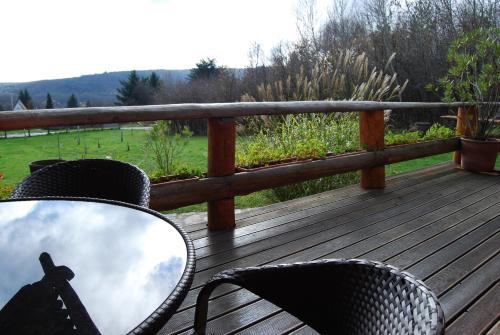 a wooden deck with two chairs and a mirror at Boróka Apartmanházak - Gerenda Ház in Velem