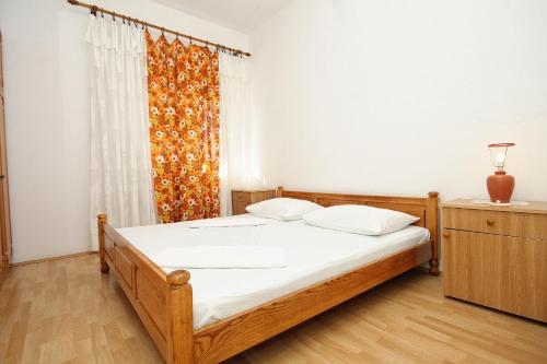 a bedroom with a wooden bed and a window at Apartments by the sea Lumbarda, Korcula - 4358 in Lumbarda