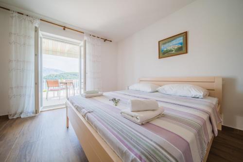 a bedroom with a large bed with two towels on it at Apartment Lumbarda 4446b in Lumbarda