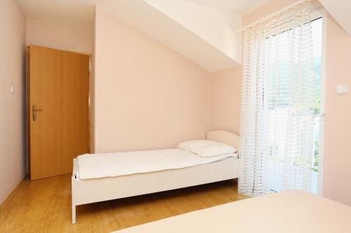 1 dormitorio con 2 camas y ventana en Apartment Zuljana 4576a en Žuljana