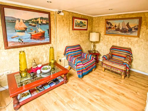 ein Wohnzimmer mit 2 Stühlen und einem Tisch in der Unterkunft Hotel Londres La Serena in La Serena